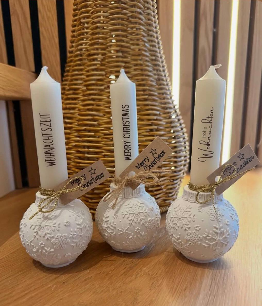 Weihnachtliche Kerzen in dekorativen Kugelhaltern